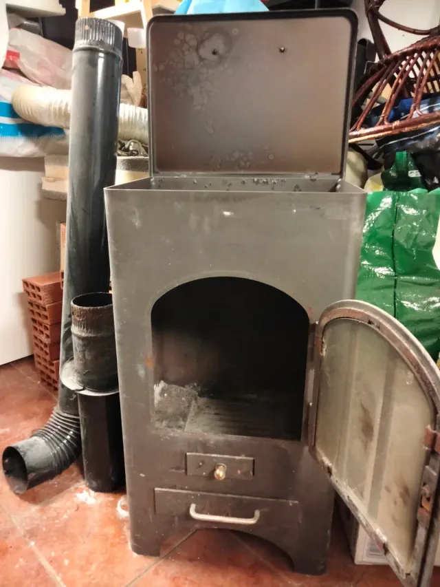 Estufa de leña metálica con puerta de cristal