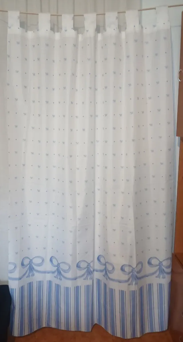 Cortinas brancas e azuis claras com laços