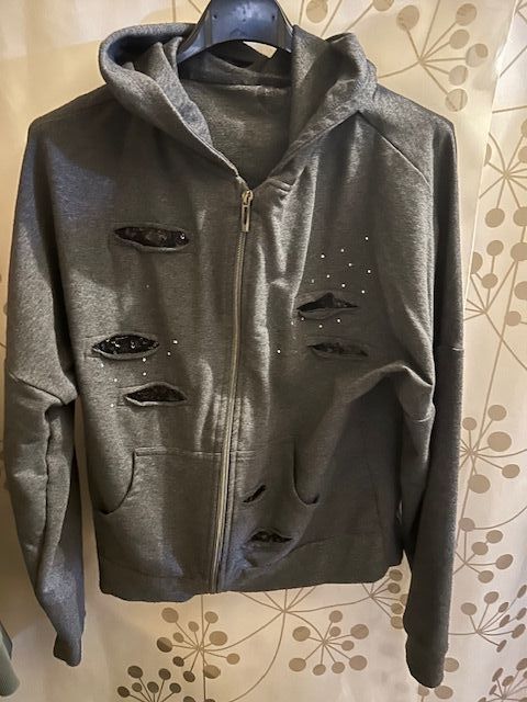 Felpa grigia con strappi e paillettes