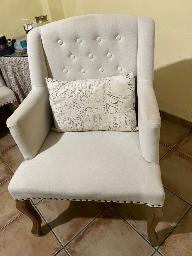 Sillón de tela beige con patas de madera