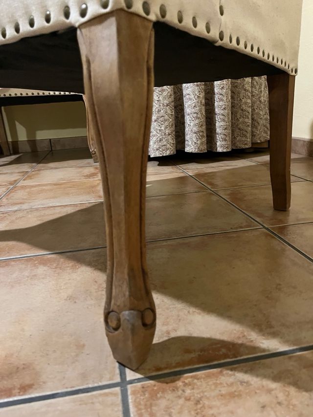 Sillón de tela beige con patas de madera