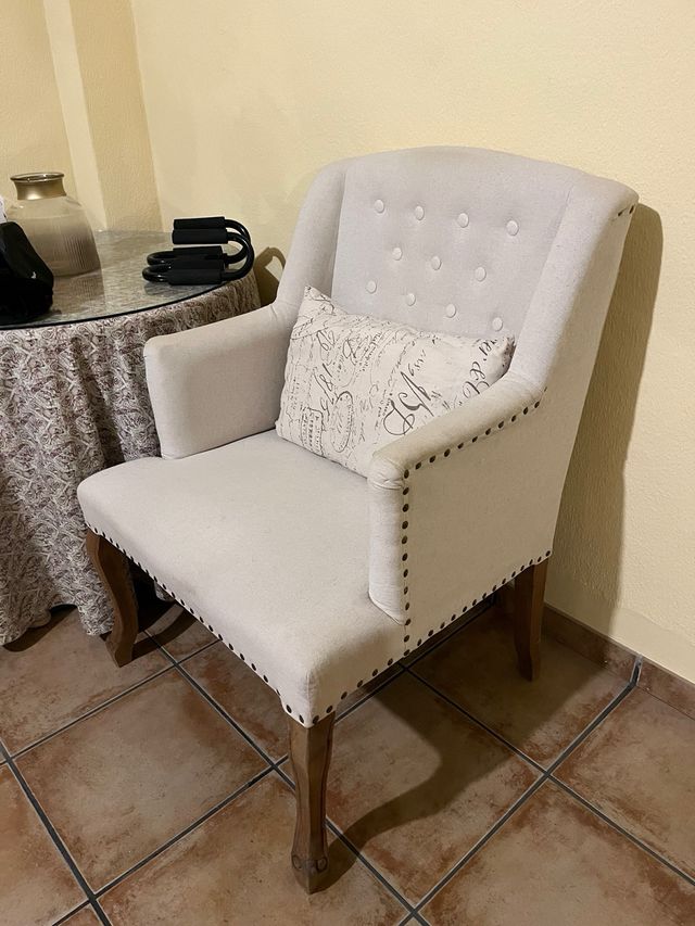 Sillón de tela beige con patas de madera