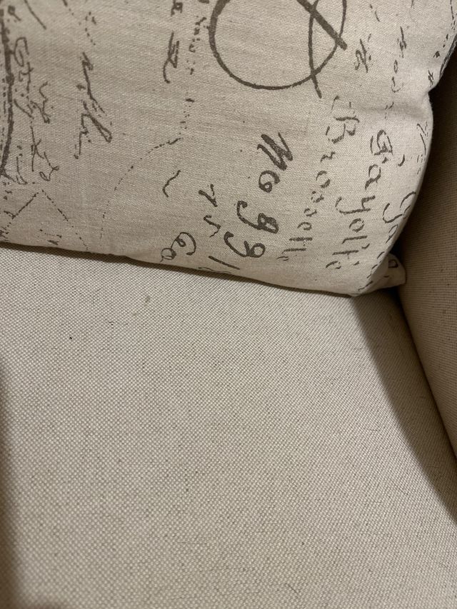 Sillón de tela beige con patas de madera