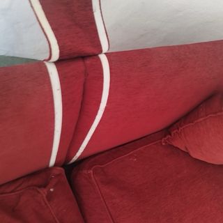 Sofá de 2 plazas rojo y beige con puf.