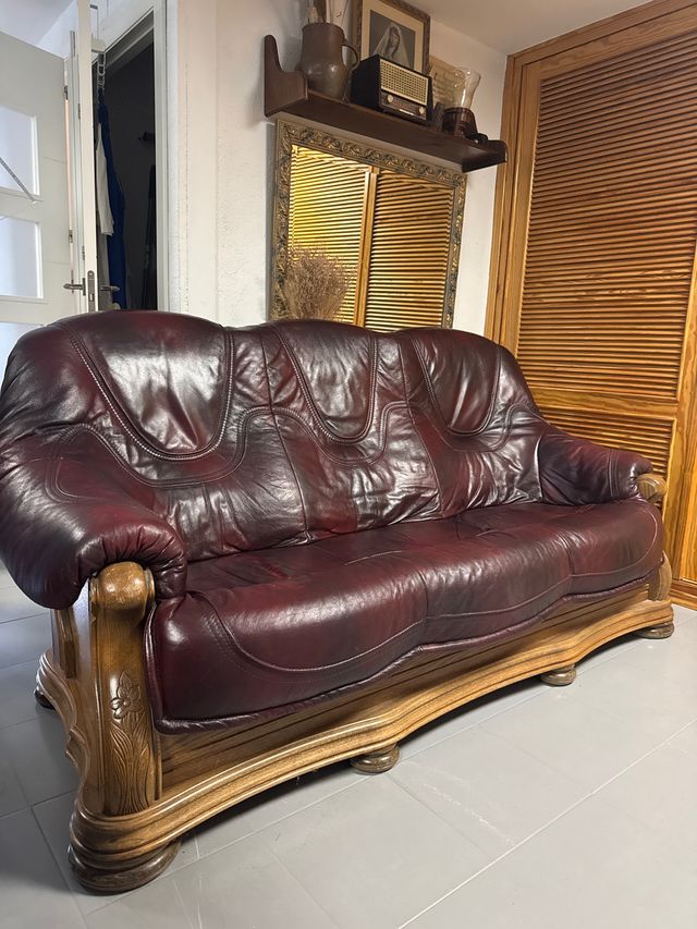 Sofá de cuero granate con estructura de madera