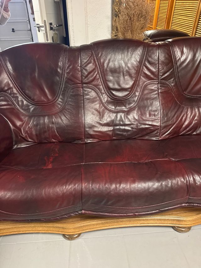 Sofá de cuero granate con estructura de madera