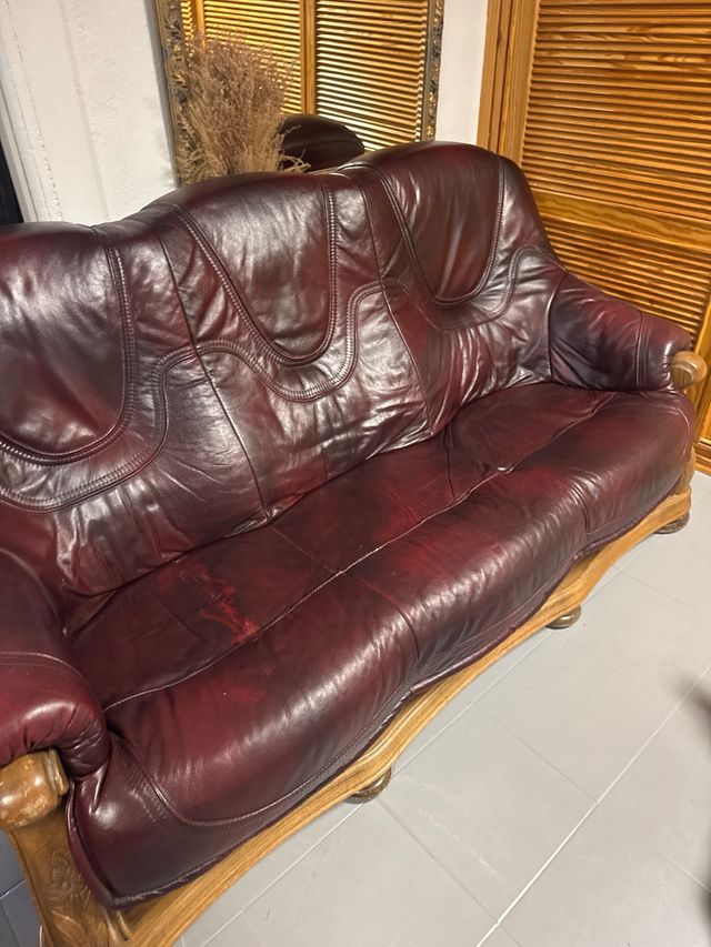 Sofá de cuero granate con estructura de madera