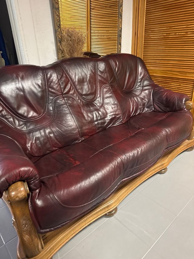 Sofá de cuero granate con estructura de madera