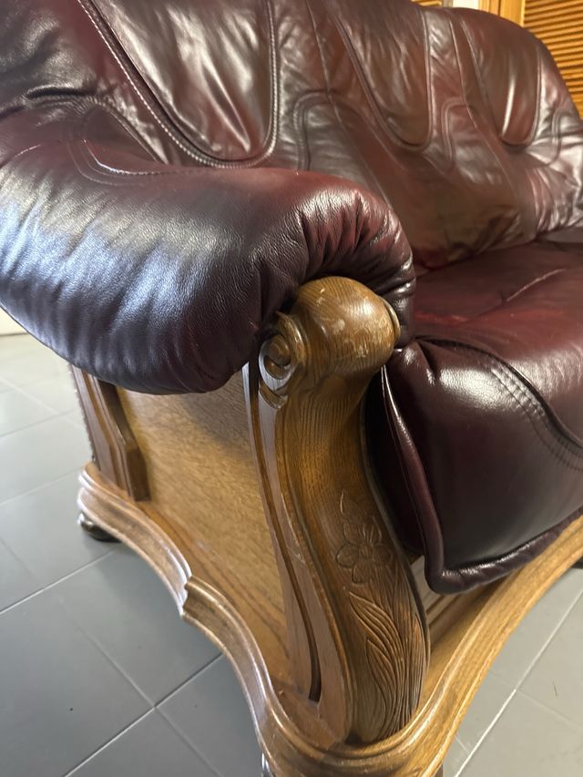 Sofá de cuero granate con estructura de madera