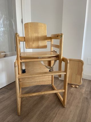 Trona de madera convertible en pupitre.