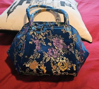 Bolso de mano azul con estampado floral