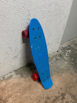 Monopatín azul con ruedas rojas