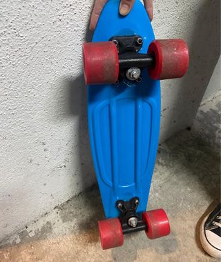 Monopatín azul con ruedas rojas