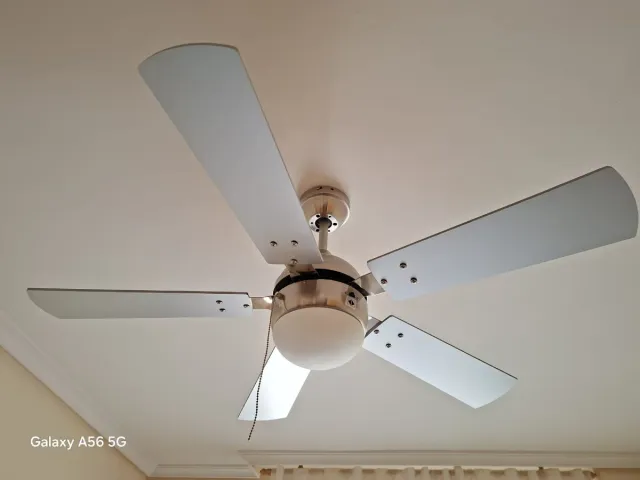 Ventilador de techo plateado con luz.