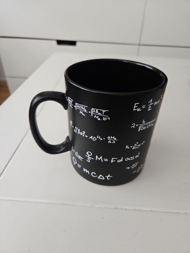 Taza negra con fórmulas científicas