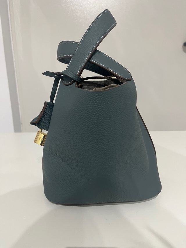 Bolso de mano azul con candado dorado