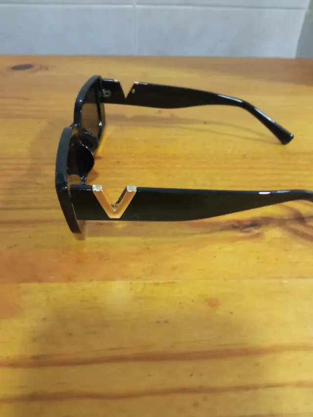 Gafas de sol rectangulares negras con detalle dora