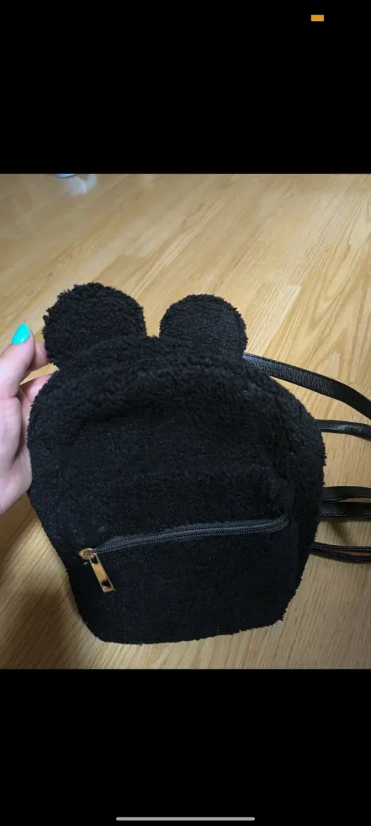 Mochila de peluche negra con orejas