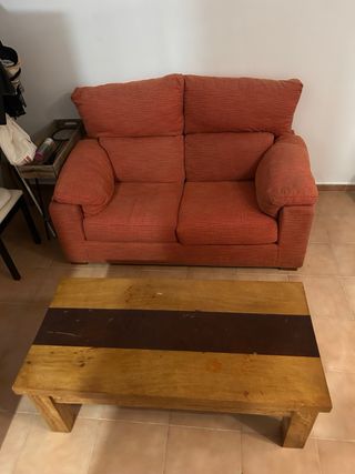 Sofá biplaza naranja y mesa centro madera