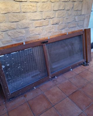 Puerta de aluminio con cristal y persianas.