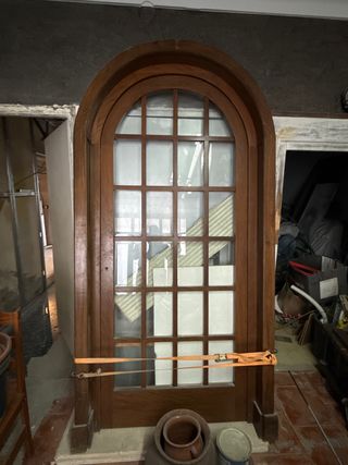 Puerta de madera con arco y cristal