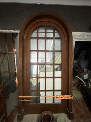 Puerta de madera con arco y cristal