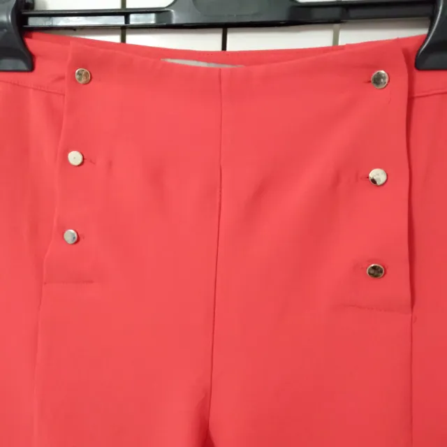 Pantaloni color fucsia leggeri con bottoni dorati.