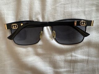 Gafas de sol Gucci negras y doradas.