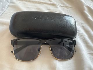 Gafas de sol Gucci negras y doradas.