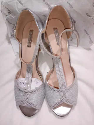 Zapatos de fiesta plateados y bolso a juego.