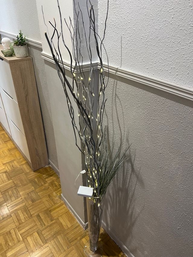 Jarrón de cristal con ramas decorativas