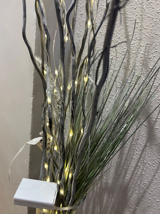 Jarrón de cristal con ramas decorativas