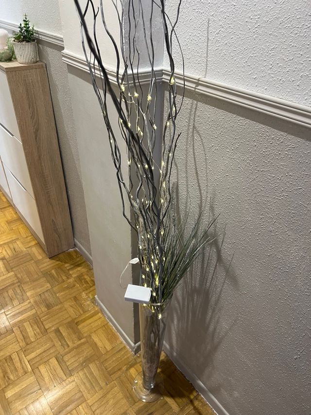 Jarrón de cristal con ramas decorativas