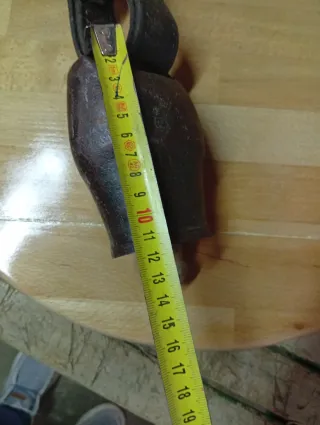 Cencerro antiguo con correas de cuero.