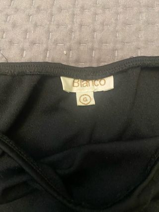 Falda negra con bordado floral rojo y flecos.