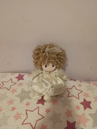 Muñeca de peluche con vestido blanco.
