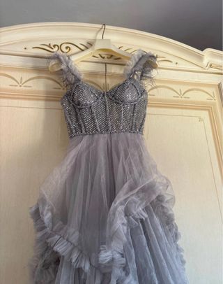 Abito lungo grigio con strass e piume