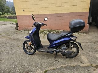 Ciclomotor azul con baúl