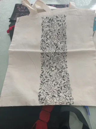 Bolsas de tela pintadas y una con pompones.