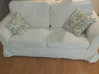 Sofá blanco con cojines decorativos