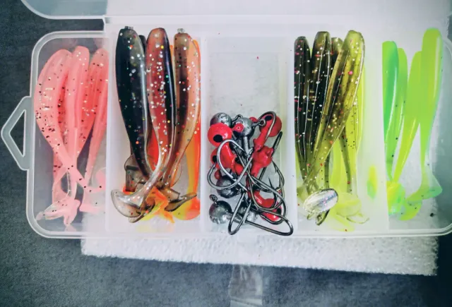 Caña de pesca y carrete con señuelos