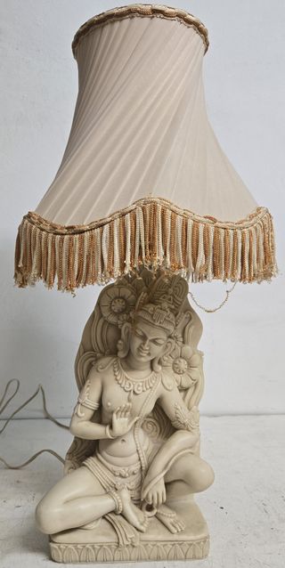 Lámpara de mesa vintage con flecos y figura.