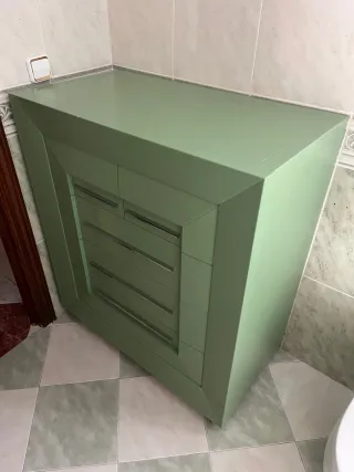Mueble de baño verde con detalles plateados