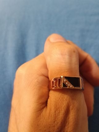 Anillo dorado con detalles negros y brillos