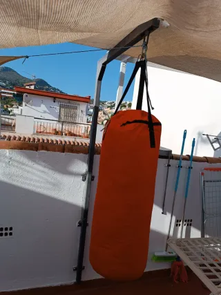 Saco de boxeo naranja y guantes
