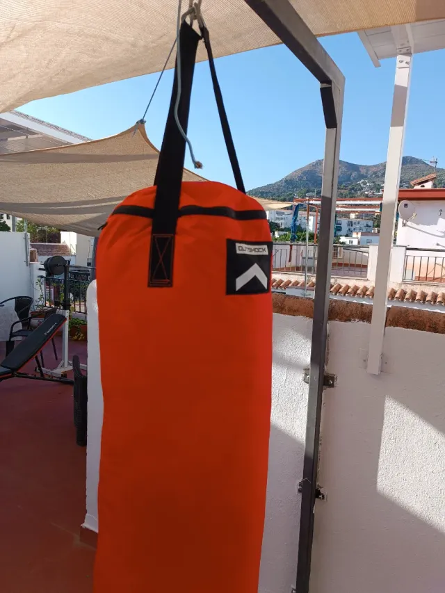 Saco de boxeo naranja y guantes