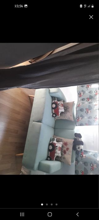 Sofá azul de tela con patas de madera
