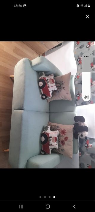 Sofá azul de tela con patas de madera