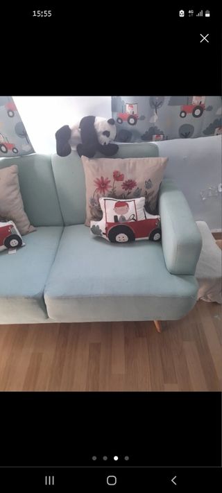 Sofá azul de tela con patas de madera