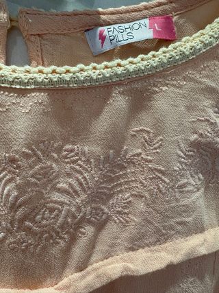 Blusa ricamata a maniche lunghe rosa pesca.